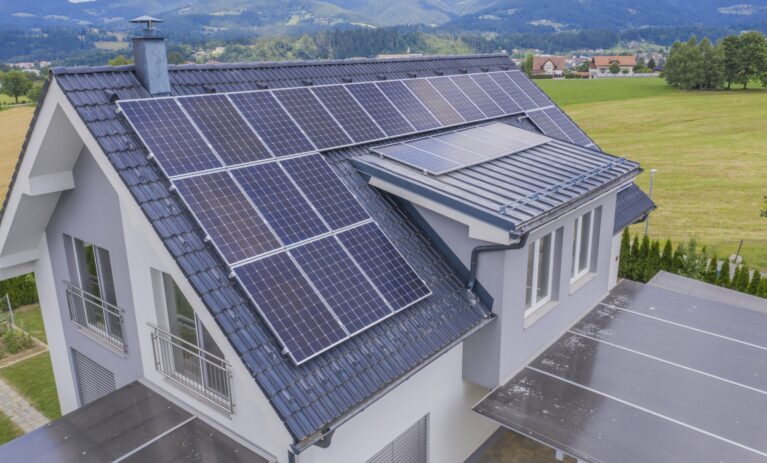High angle shot of a private house situated in a valley with solar panels on the roof A high angle shot of a private house situated in a valley with solar panels on the roof
